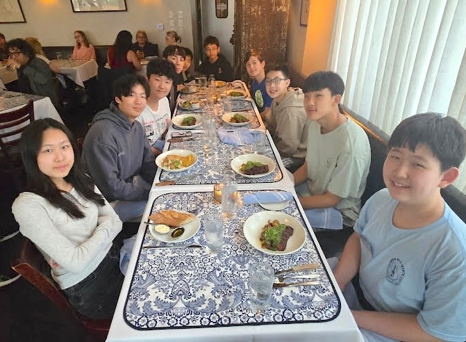 group of people at a long dinner table, looking towards the camera