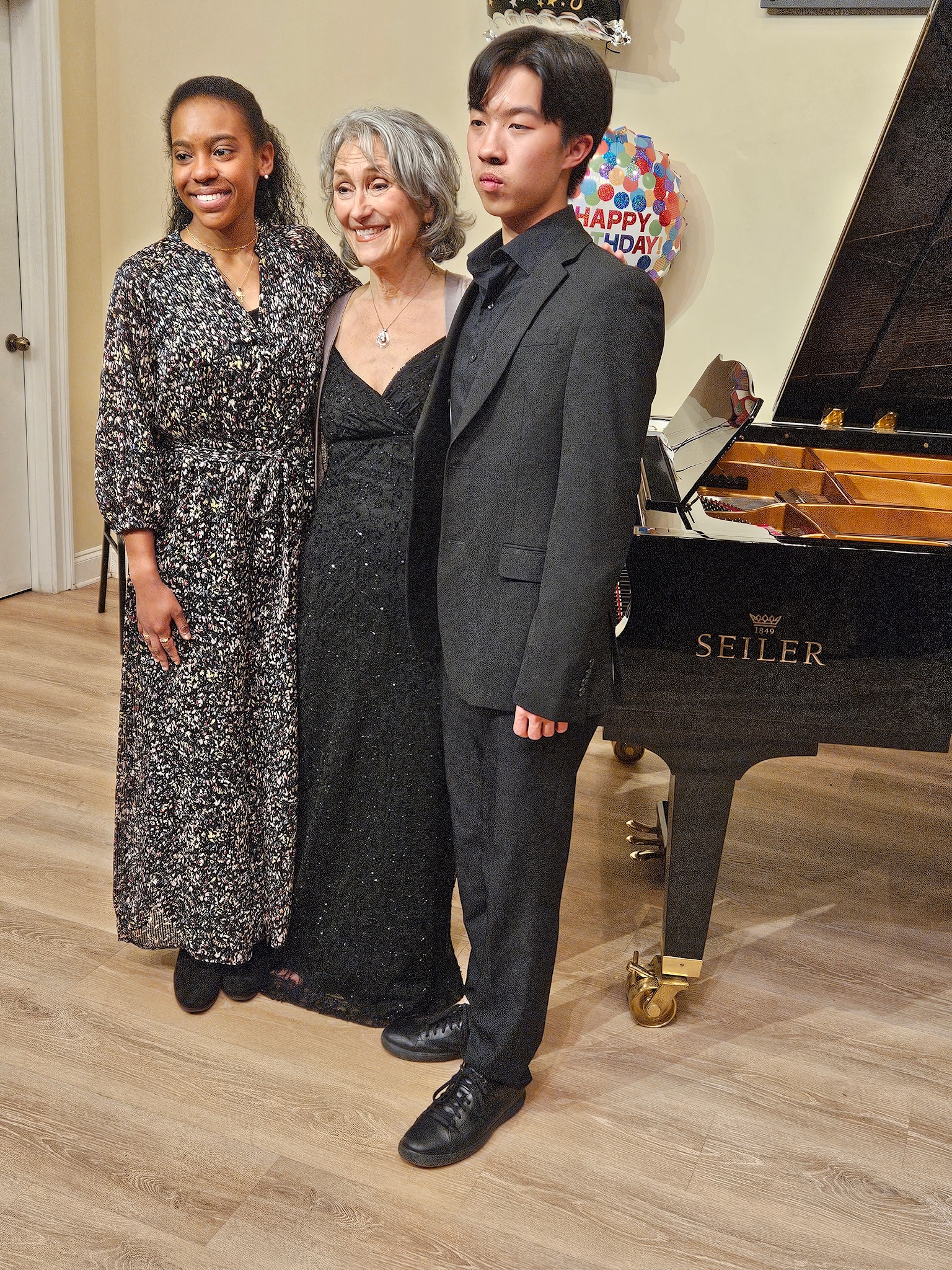 Jaia, Shirley, Andy three musicians posing in front a piano
