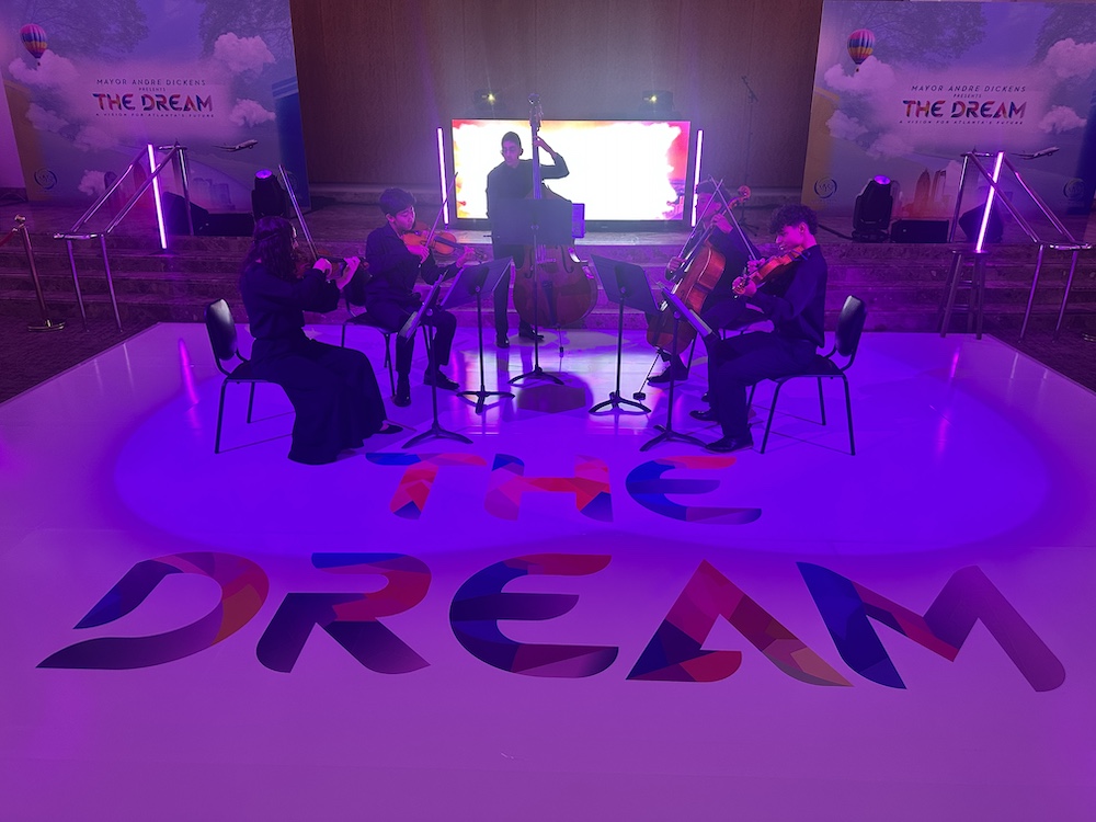 five string musicians performing in an event space with ambient lighting